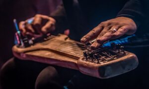 Nahaufnahme eines Slide-Gitarristen mit Bottleneck auf den Saiten