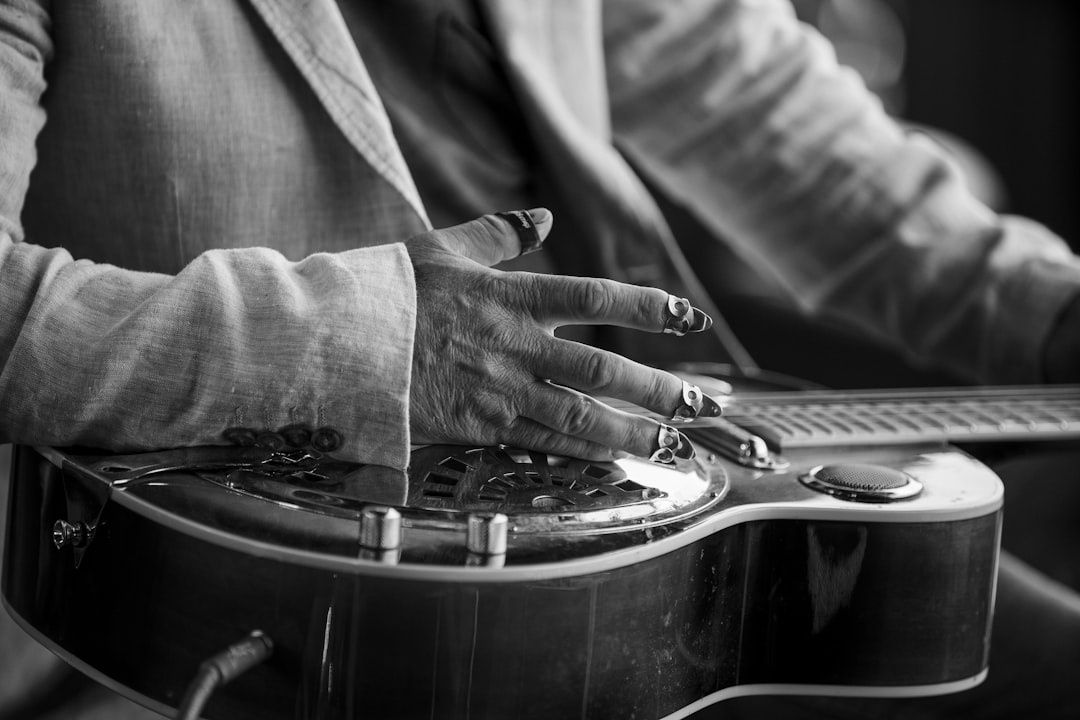 Nahaufnahme eines Musikers mit Resonatorgitarre im Schwarz-Weiß-Foto