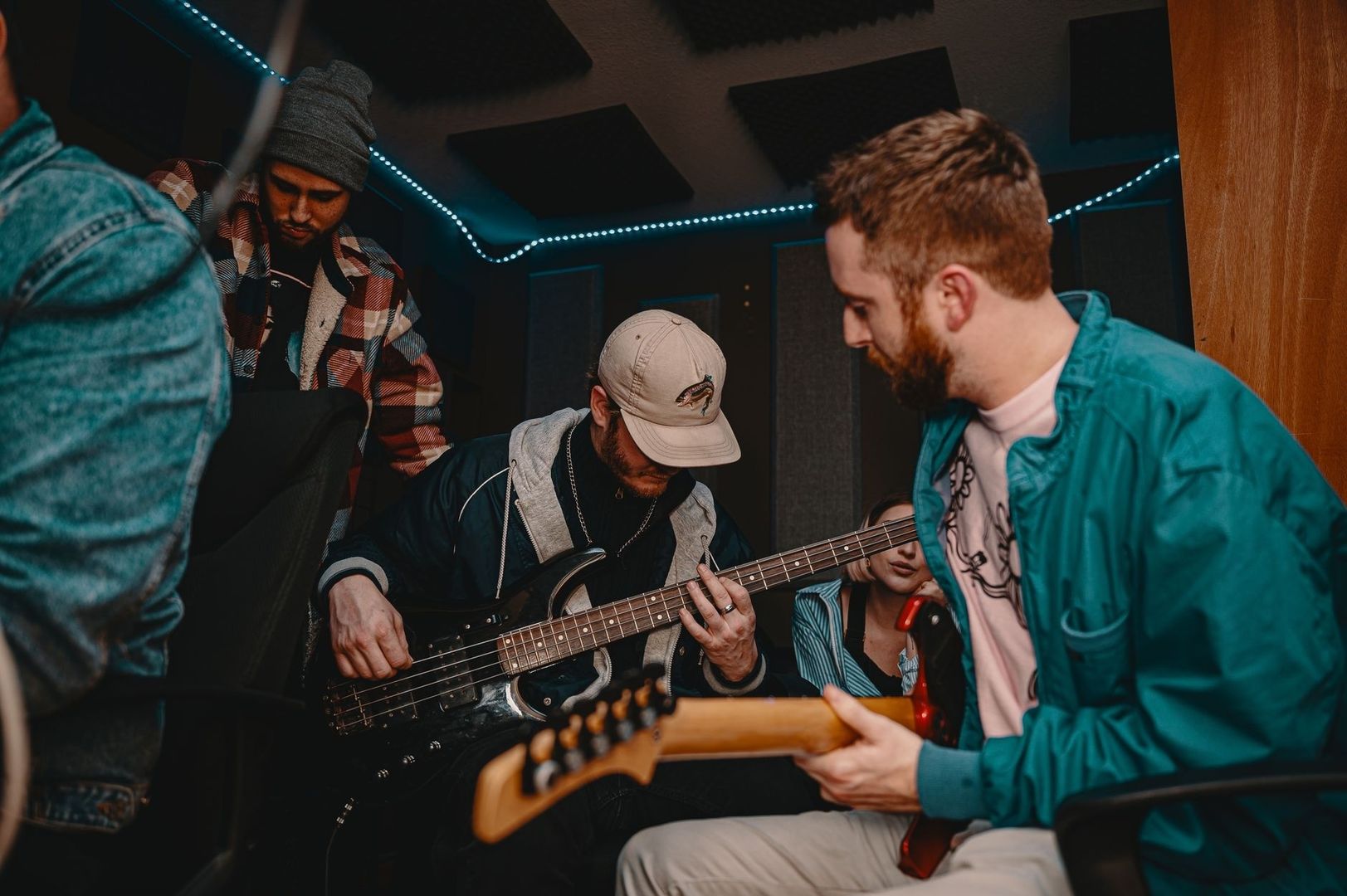 Musiker spielen gemeinsam in einem kleinen, beleuchteten Proberaum