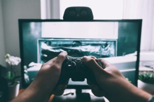 Person spielt mit einem Controller ein Videospiel am Fernseher
